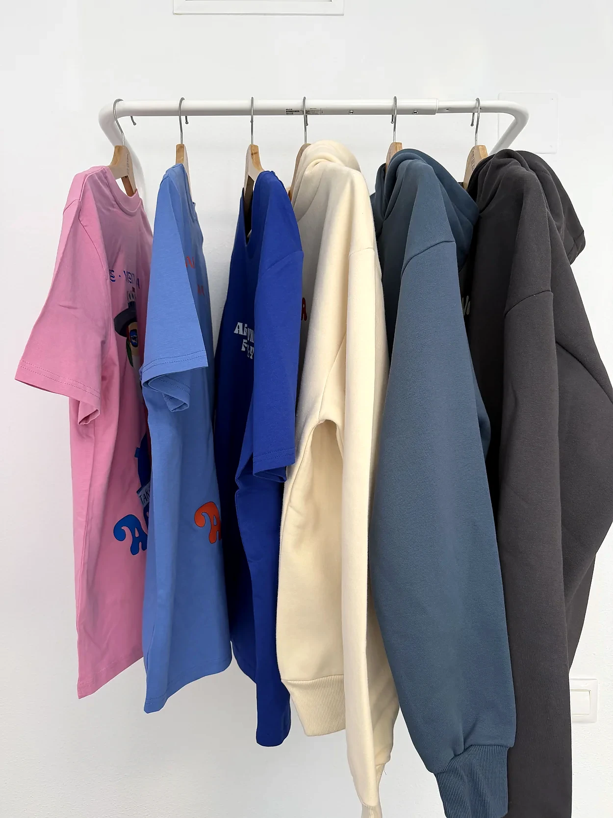Selección de camisetas y sudaderas personalizadas para Arte Vida en perchero