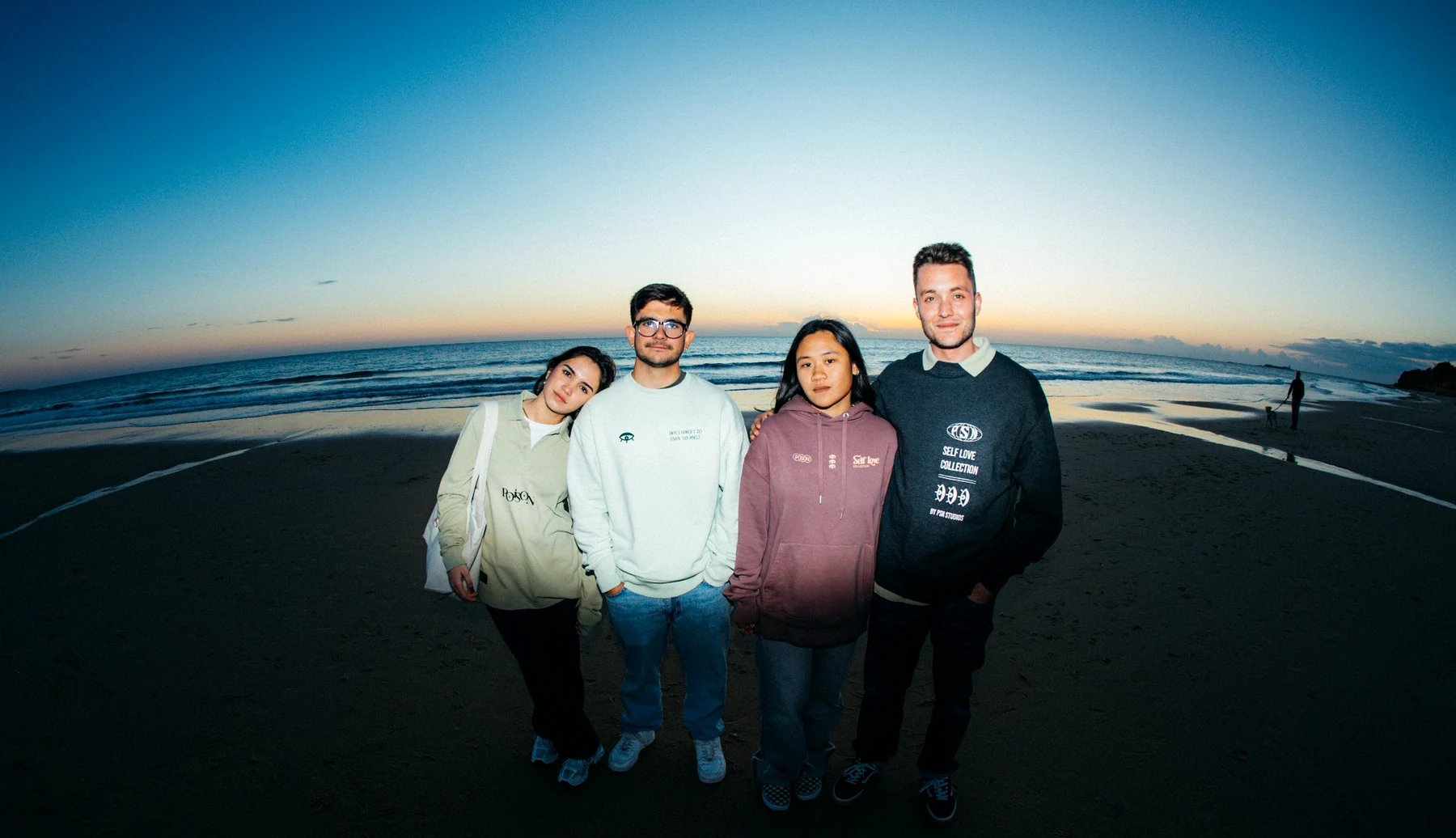 Grupo de cuatro personas con prendas personalizadas de Poison Atelier en la playa